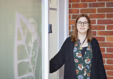 A female clinician is standing outside the clinic